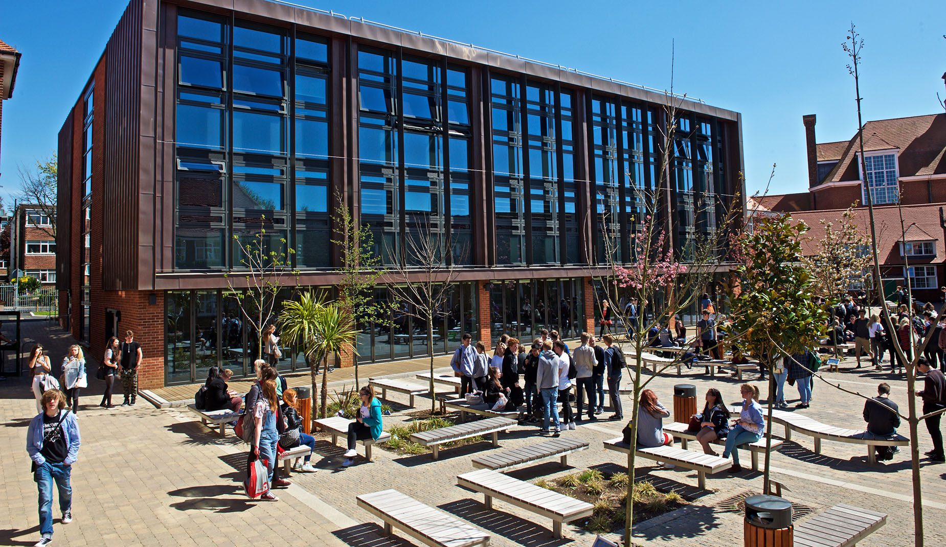People gathered around CHRONOS Benches in a courtyard